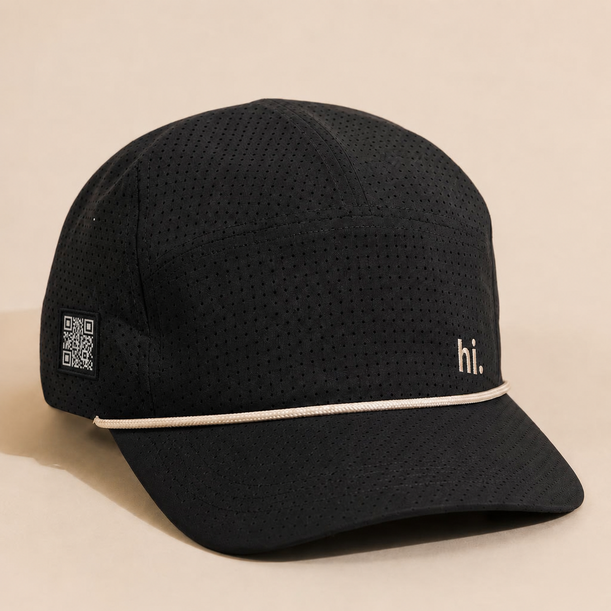 Performance Rope Hat — black with cream rope visor and a small cream 'hi.' embroidered on the front